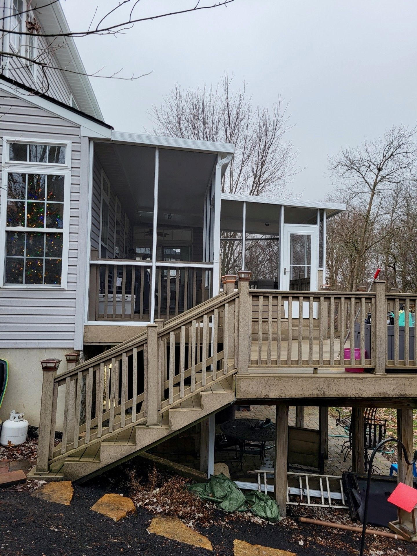 A house with a screened in porch and a wooden deck.
