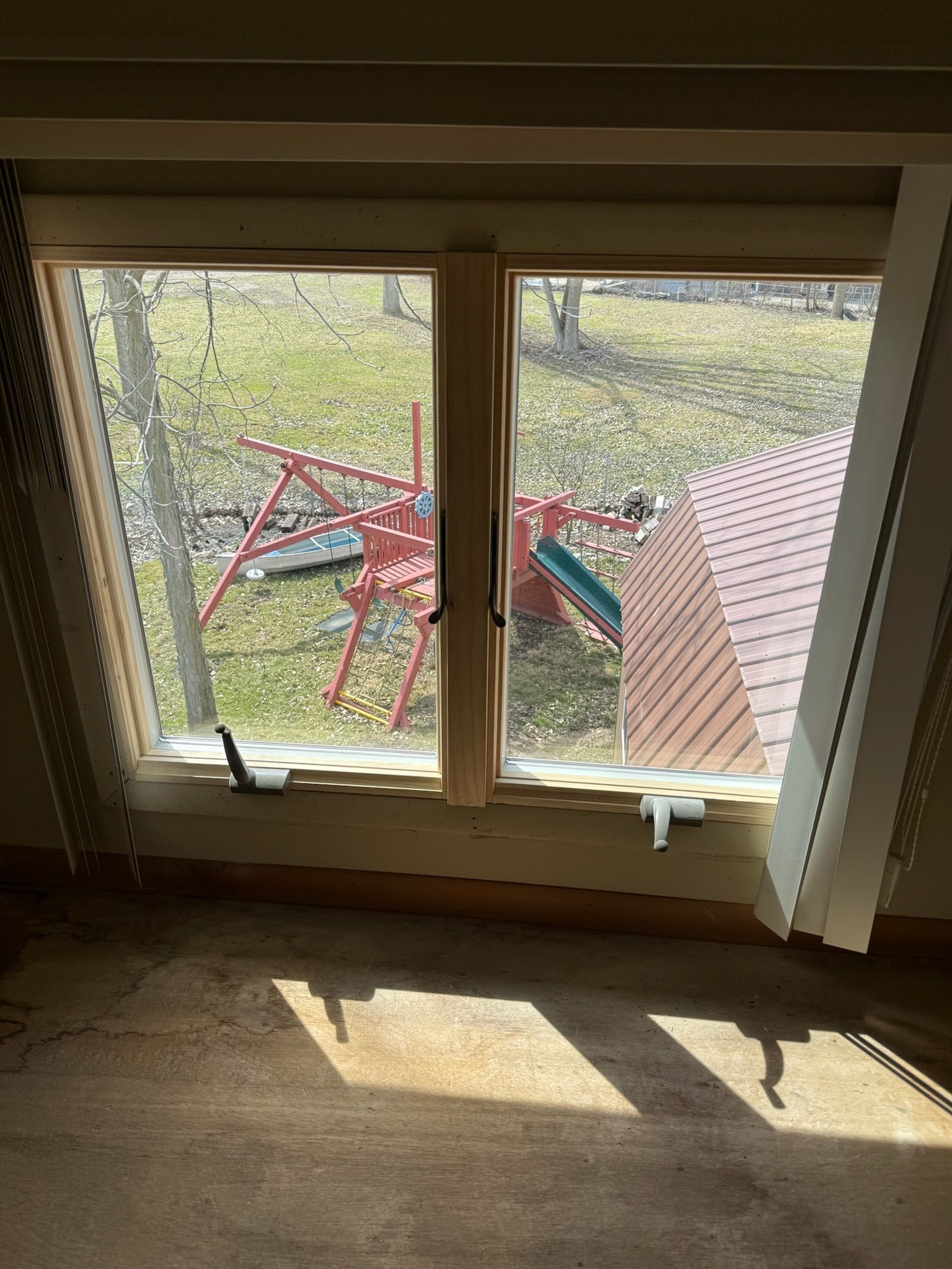 A window in a room with a view of a playground.