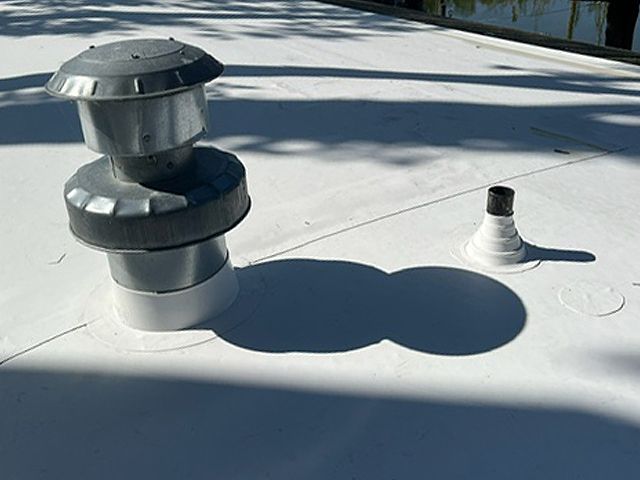 A white roof with a vent on top of it.