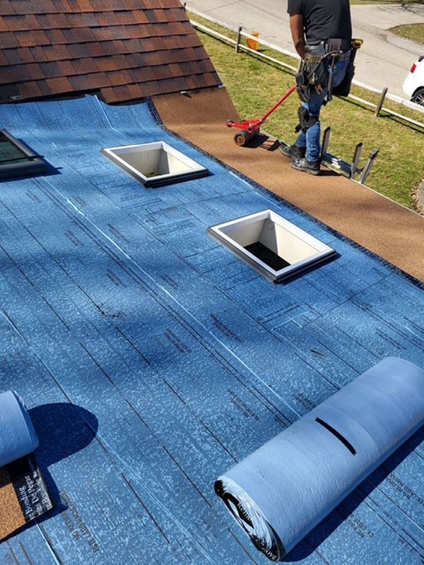 A man is standing on top of a blue roof.