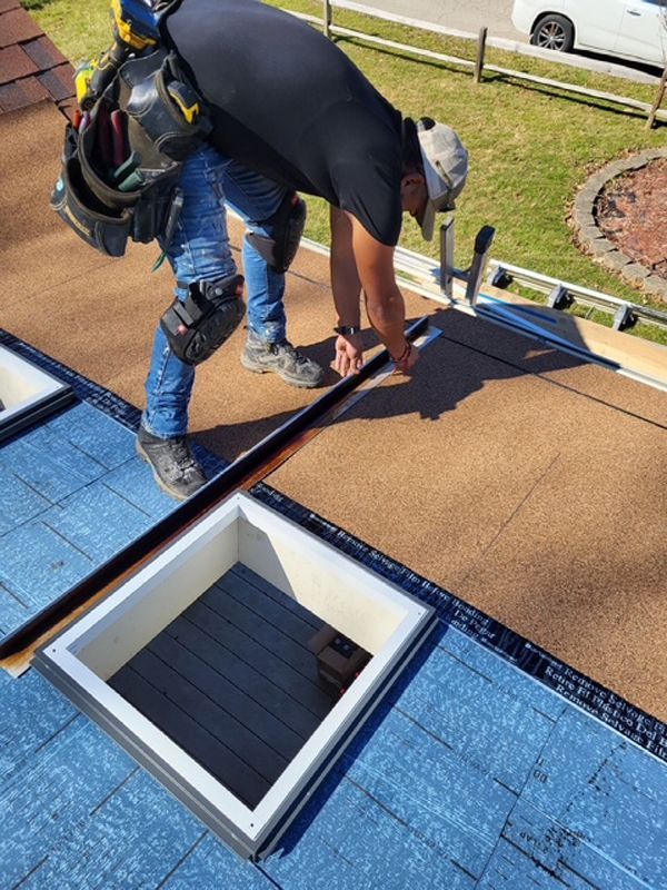 A man is working on the roof of a house.