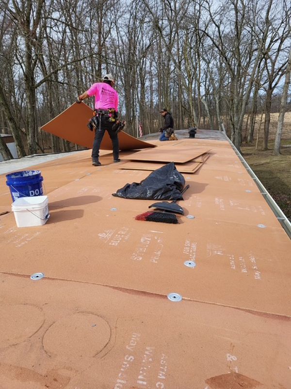 A group of men are working on a roof.