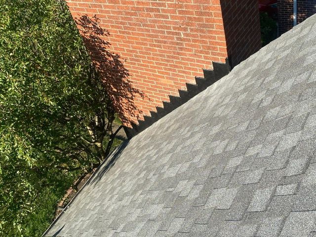 A close-up of a roof with a brick chimney