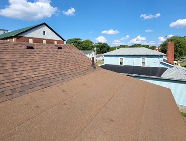 The roof of a house with a brown shingle roof