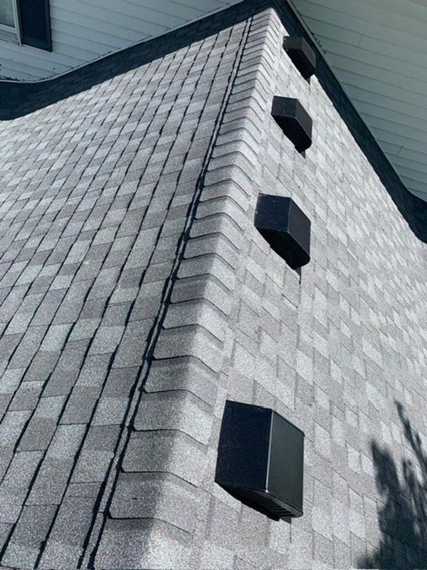 A close up of a roof with a lot of shingles and ridge