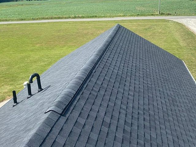 The roof of a house with a dark gray shingle roof