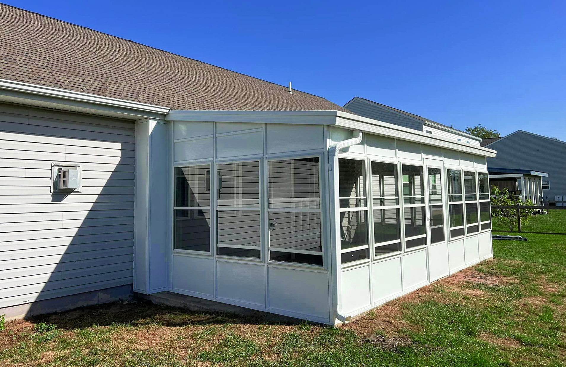 There is a screened-in porch in the backyard of the house.