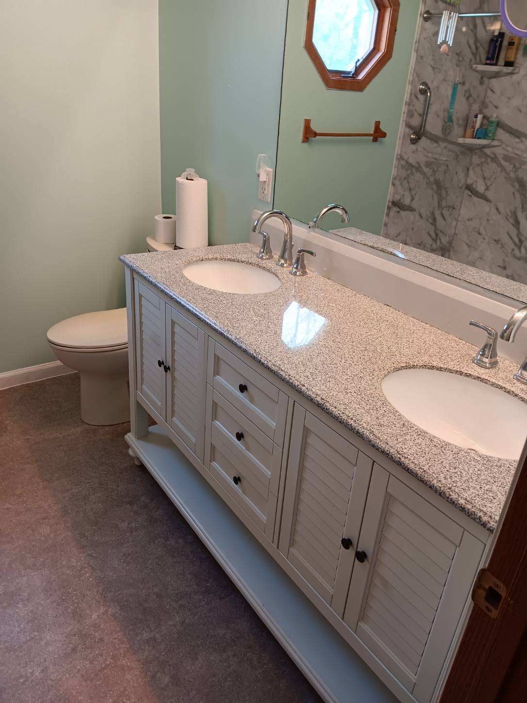 A bathroom with two sinks and a toilet
