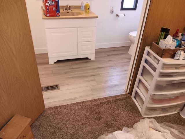 A bathroom with a sink and a bag of aquafina