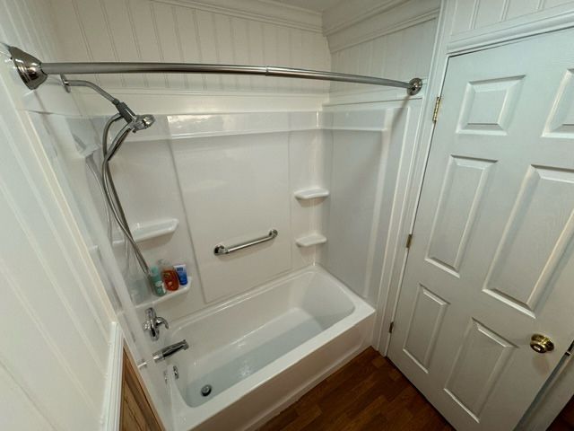 A bathroom with a bathtub and a shower.