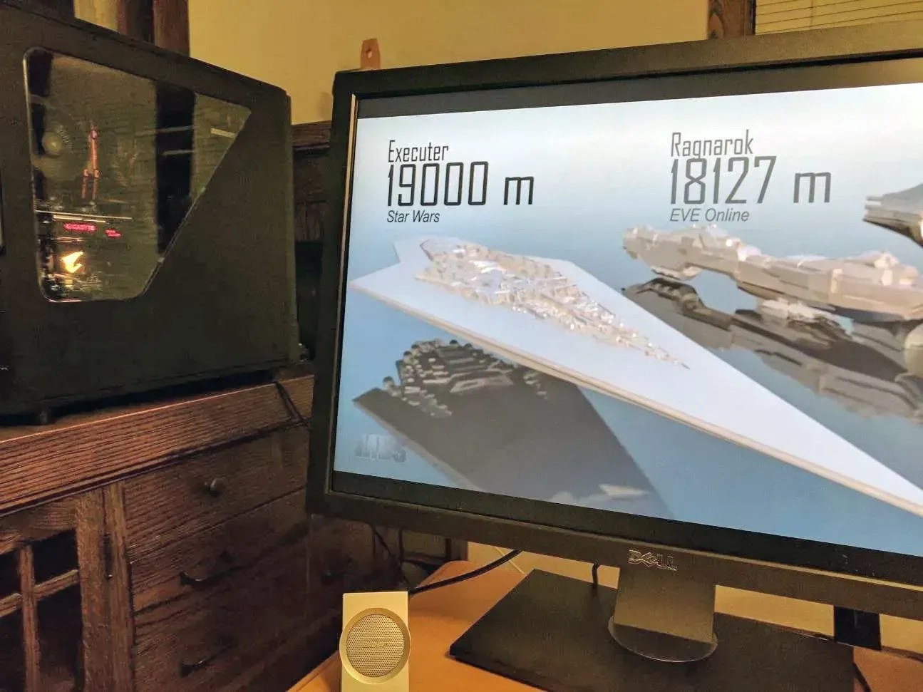 A computer monitor displaying 3D models of spaceships, next to a black computer tower.