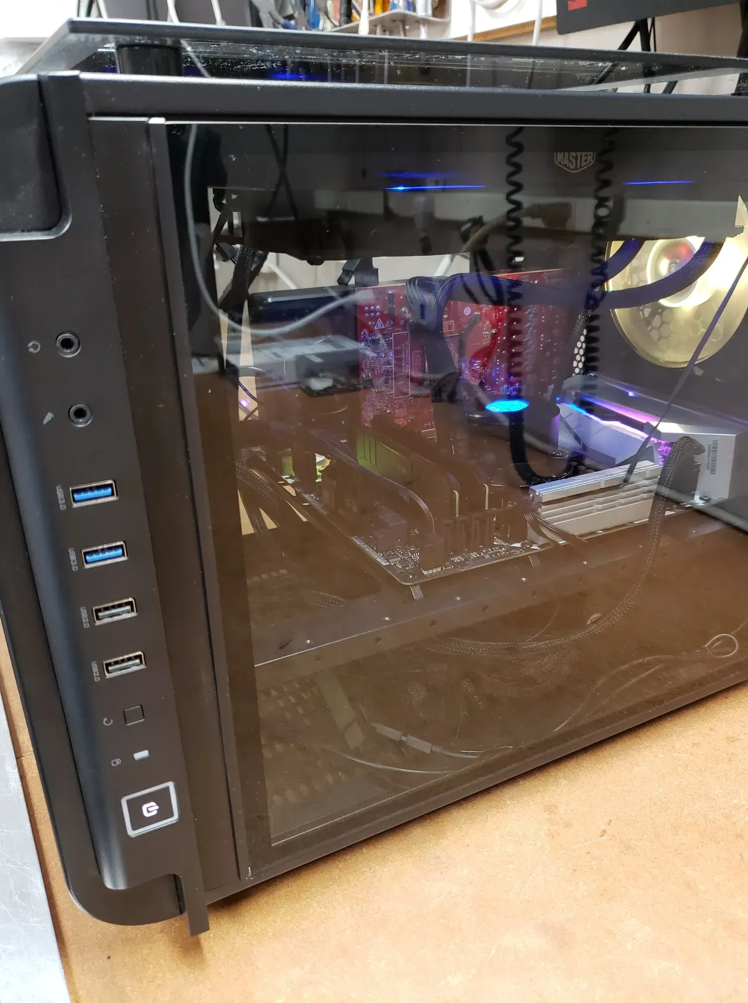 Black PC tower with a glass side panel revealing internal components and blue LED lights.