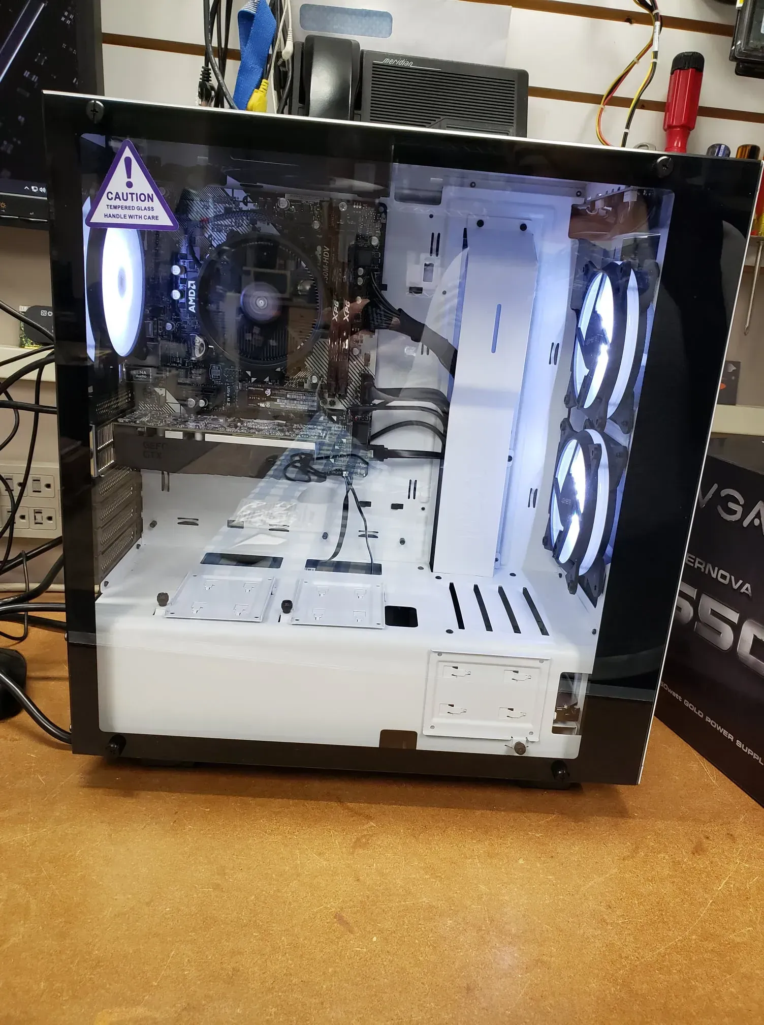 Black and white computer case with glass panel, containing illuminated components.