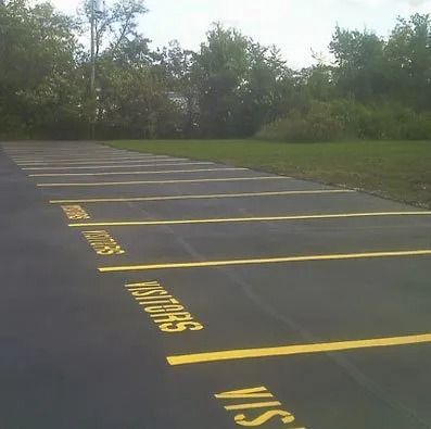 An empty parking lot with yellow-painted lines and the word 