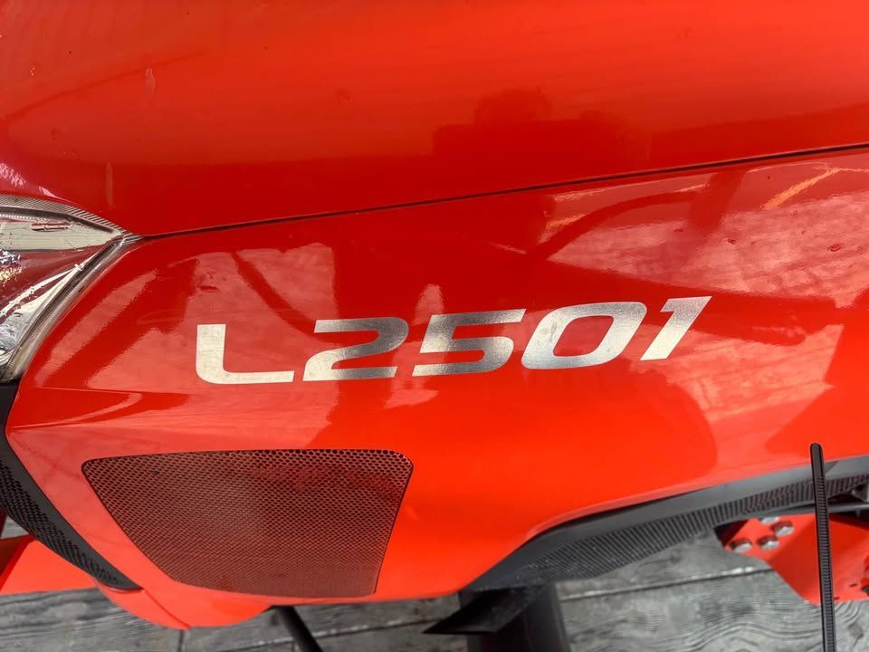 Close-up of an orange Kubota L2501 tractor showing the model number in silver lettering.