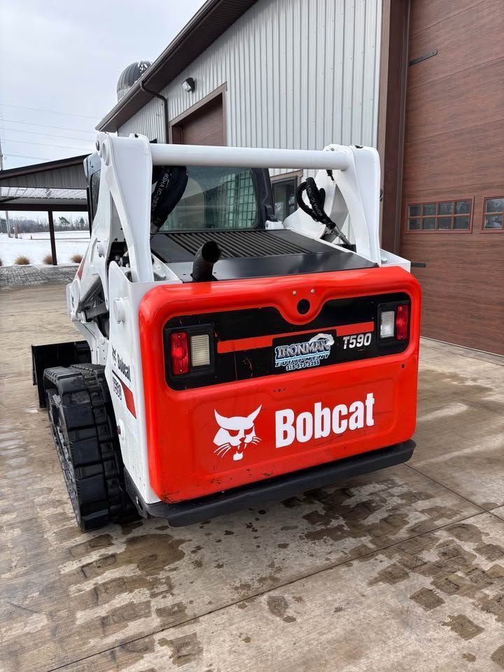 Bobcat T76 Track Loader parked outside a building, showing the rear with red and white color scheme.
