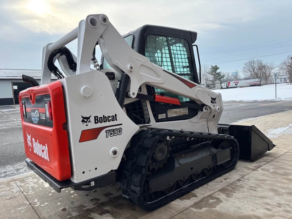 Bobcat T650 compact track loader, white and red, on a paved surface.