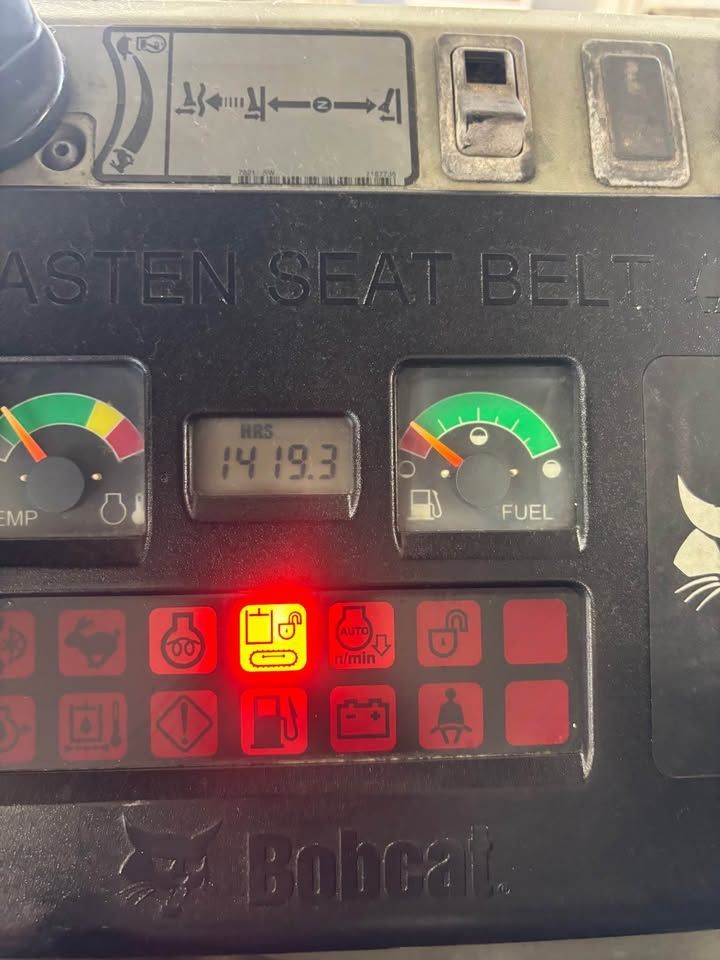 Bobcat equipment control panel with gauges, warning lights, and hour meter displaying 1419.3.