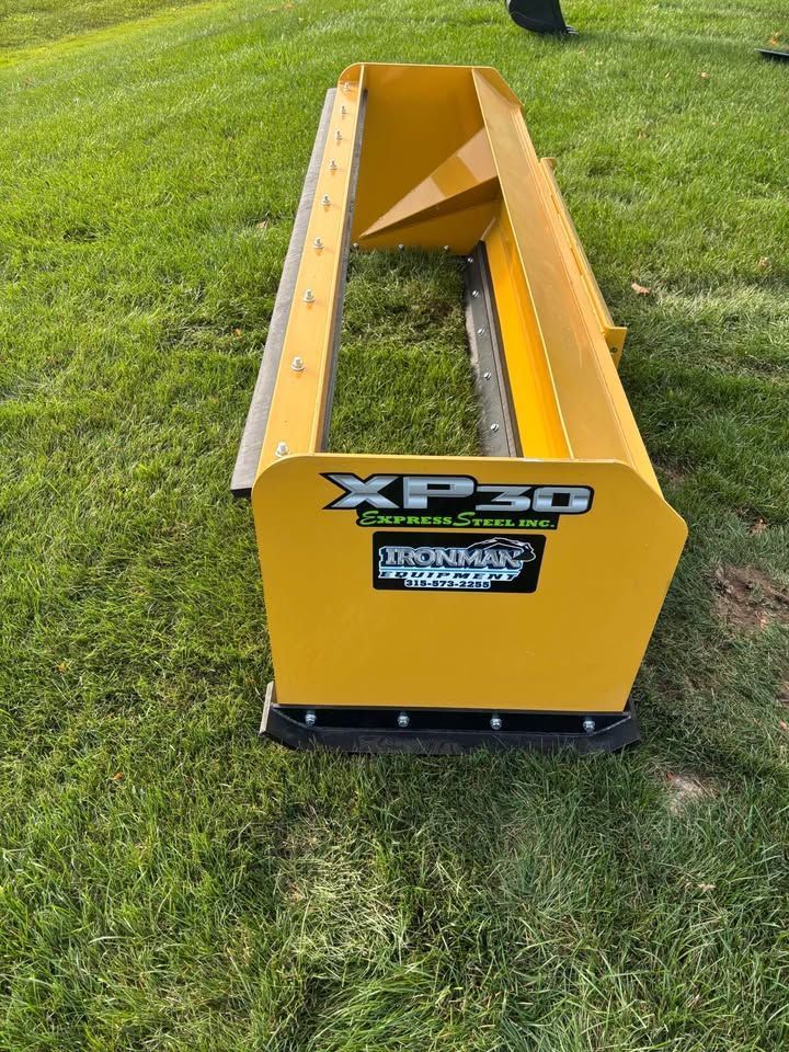 Yellow XP30 Express snow pusher on green grass.