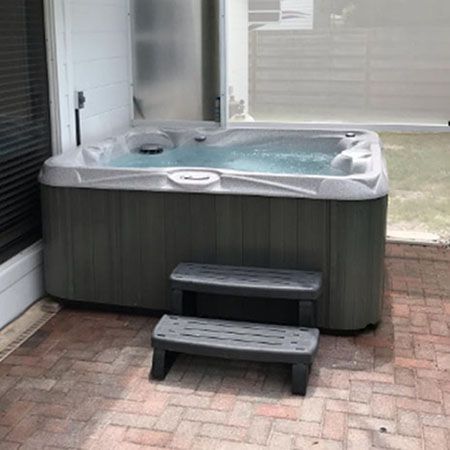 A hot tub is sitting on a wooden deck.