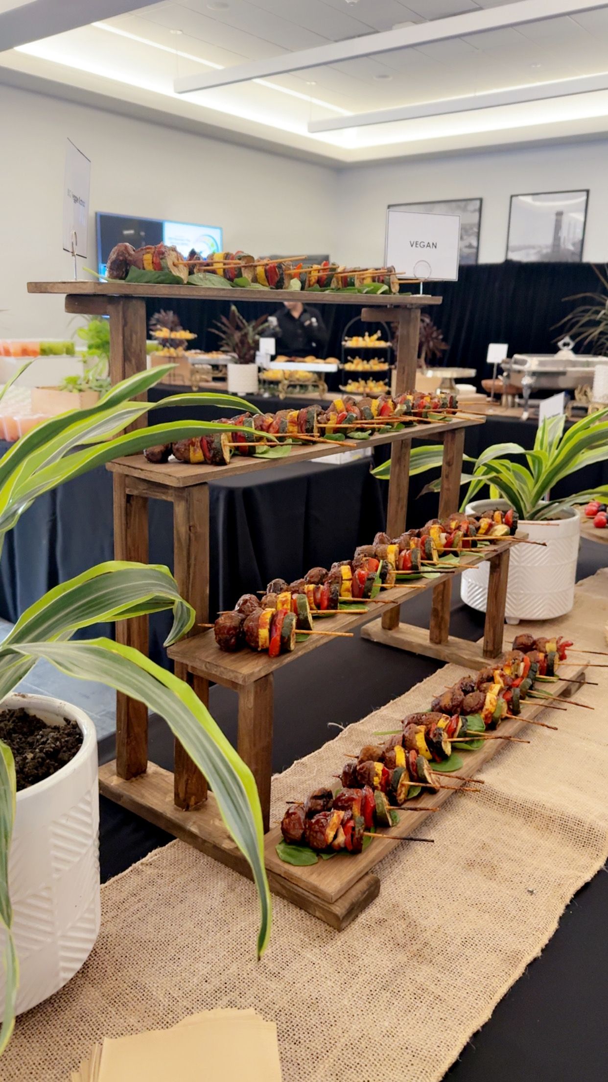 A buffet table with lots of food and plants on it.