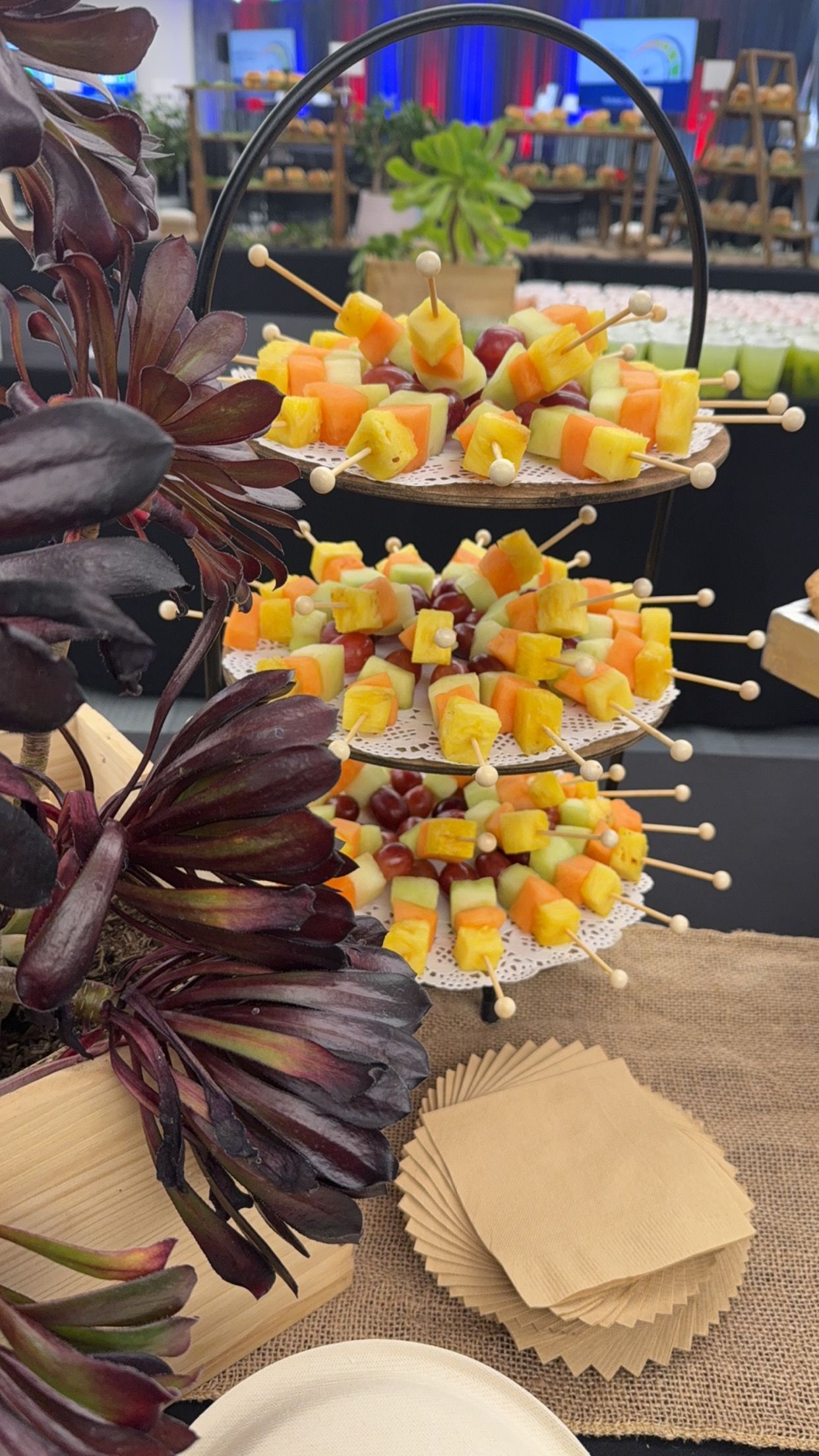 A display of fruit on skewers on a table.