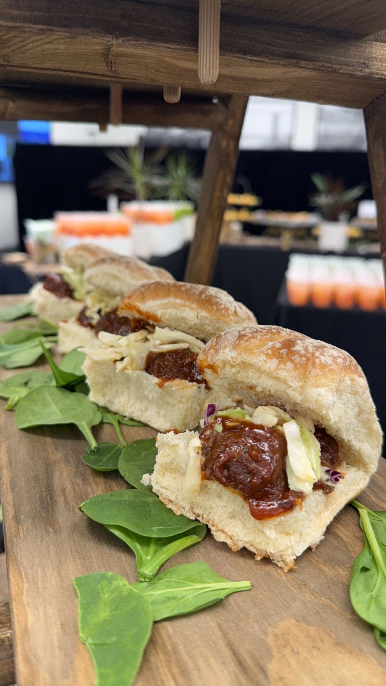 A row of sandwiches sitting on top of a wooden cutting board.