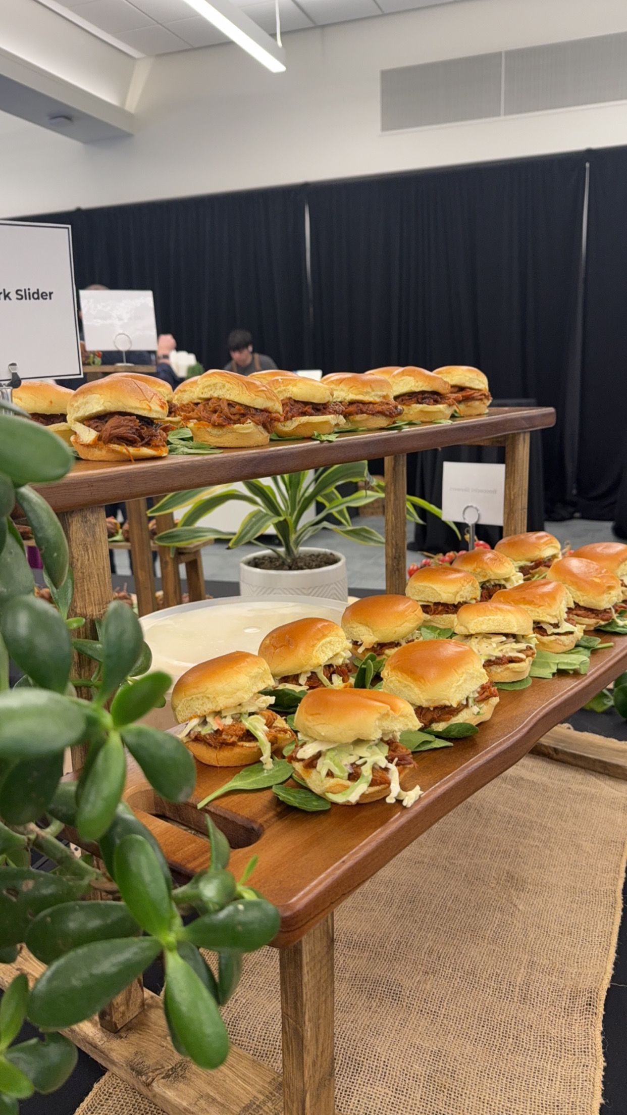 A bunch of sandwiches are sitting on a wooden table.