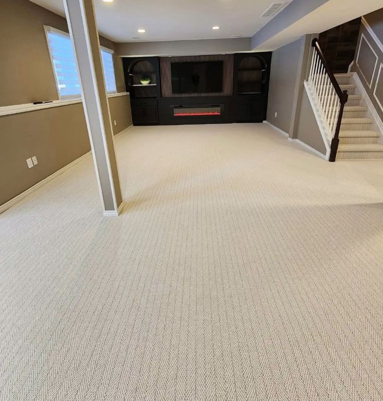 Empty carpeted basement family room with a built-in entertainment center and staircase.