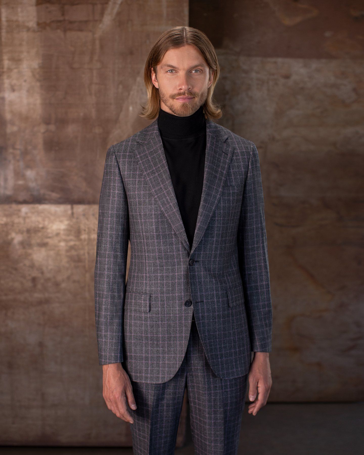 A man is wearing a suit and a black turtleneck.