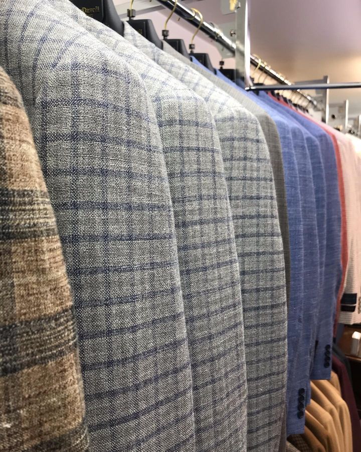 A row of jackets hanging on a rack in a store.