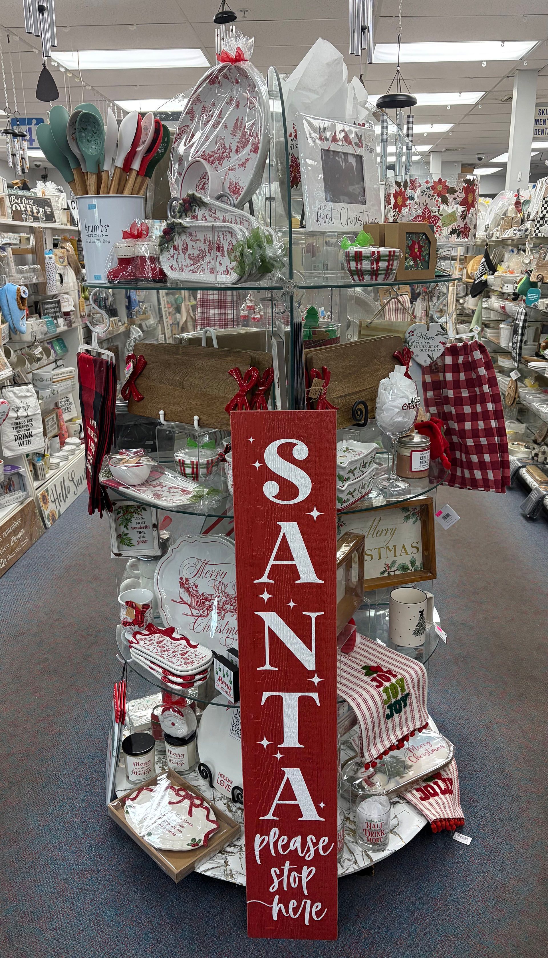 Christmas display in a store, featuring a tall red sign that reads 