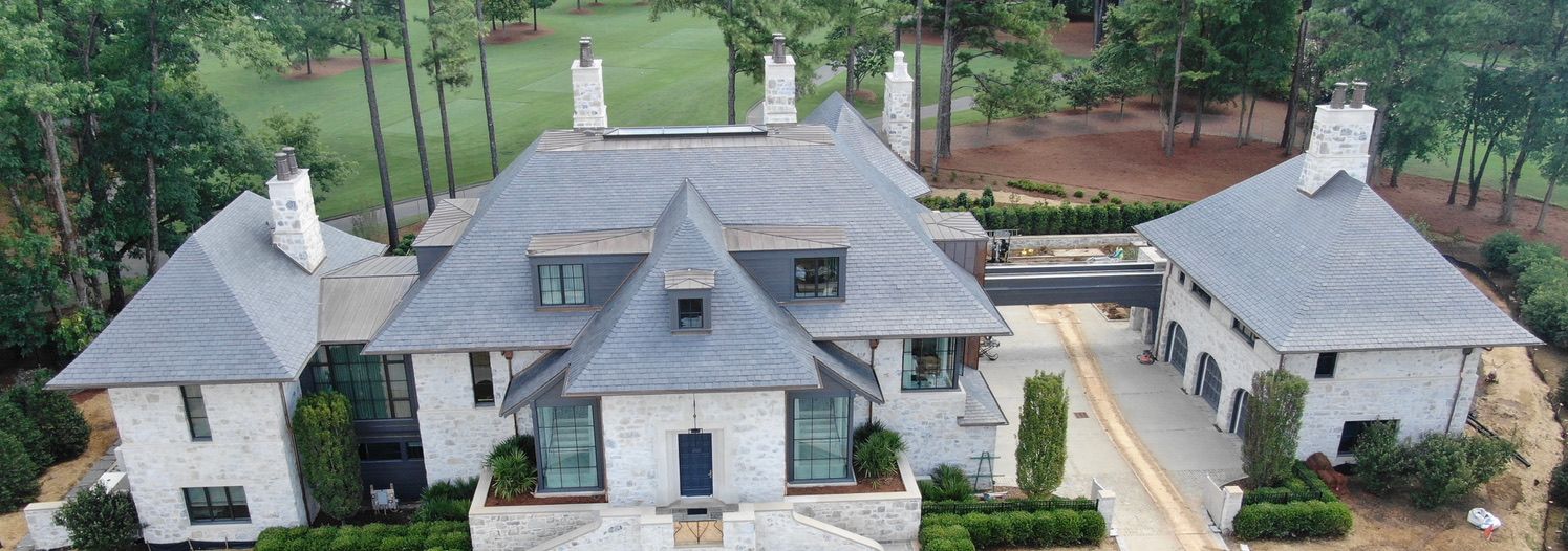 Four aerial views of a slate roof with varying angles, showing the textured gray tiles.