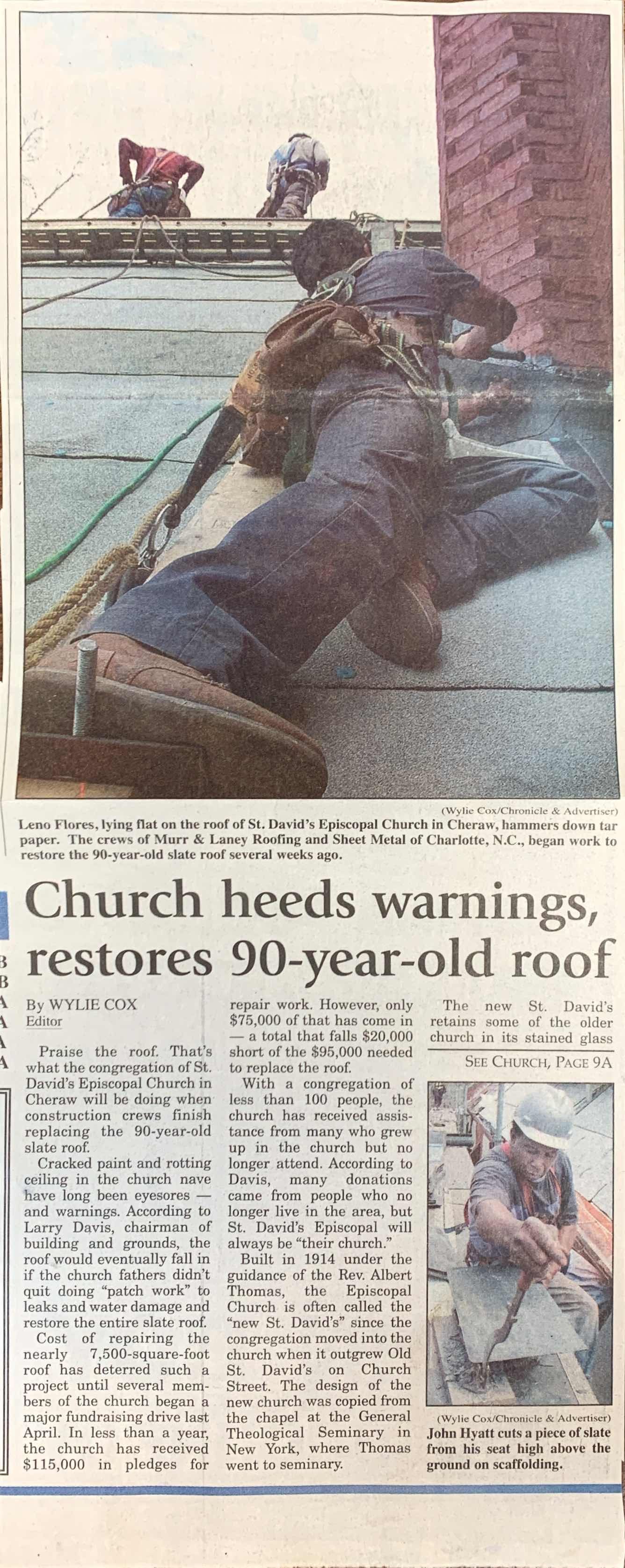 Workers repairing a 90-year-old church roof. One worker is using a tool while others are nearby.