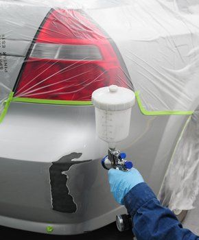 Man applying spray paint on car