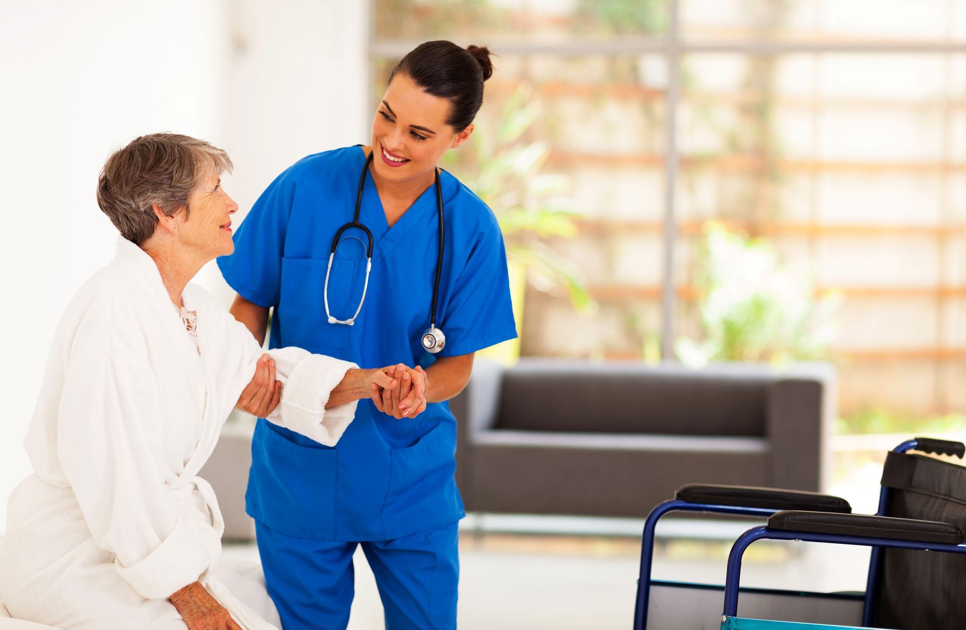 A nurse is helping an elderly woman walk with a walker.
