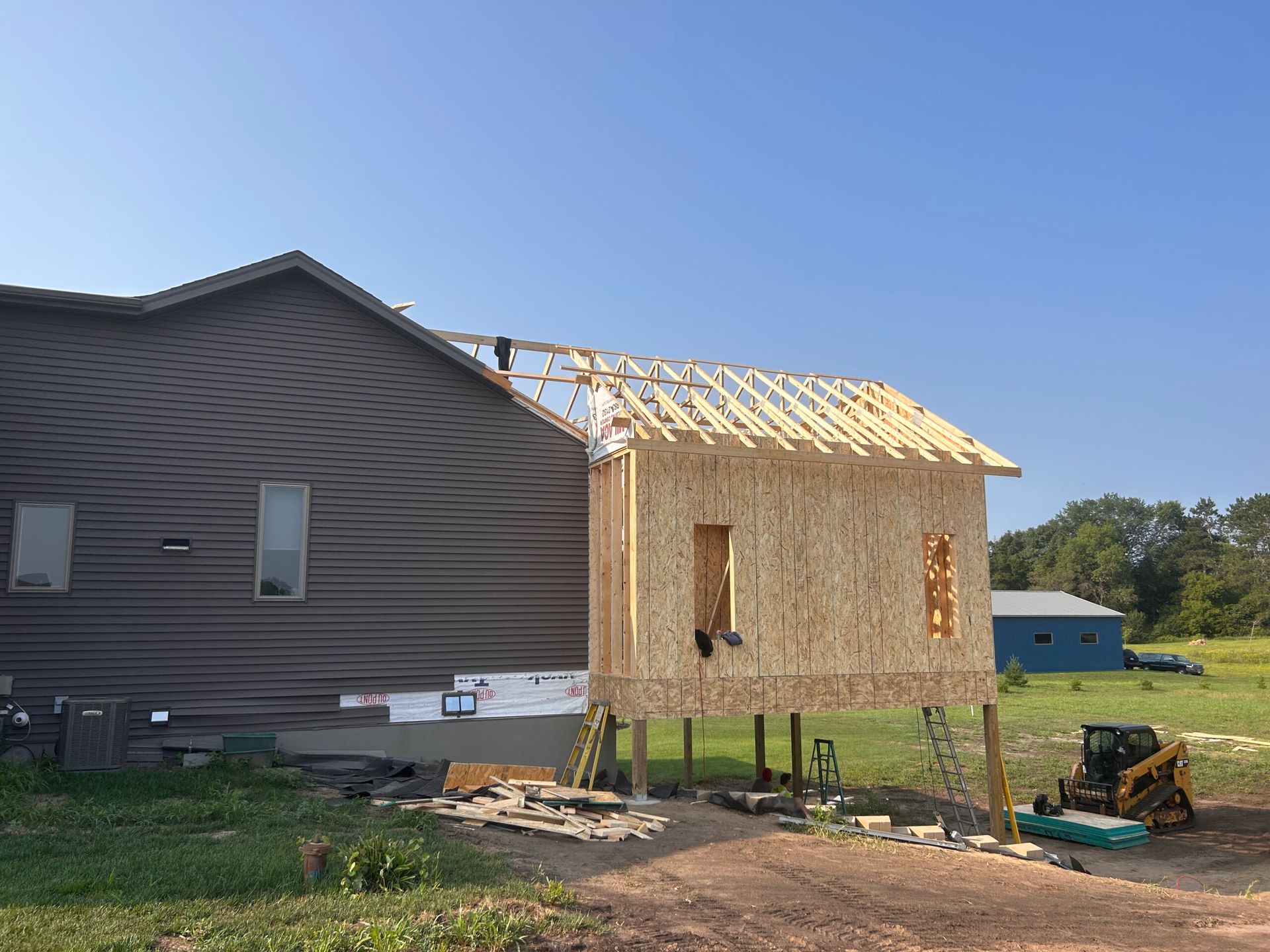 A house is being built on stilts in a field.