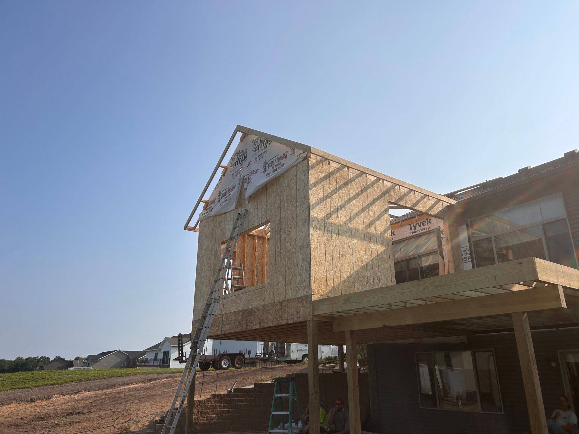 A house is being built with a ladder in front of it.