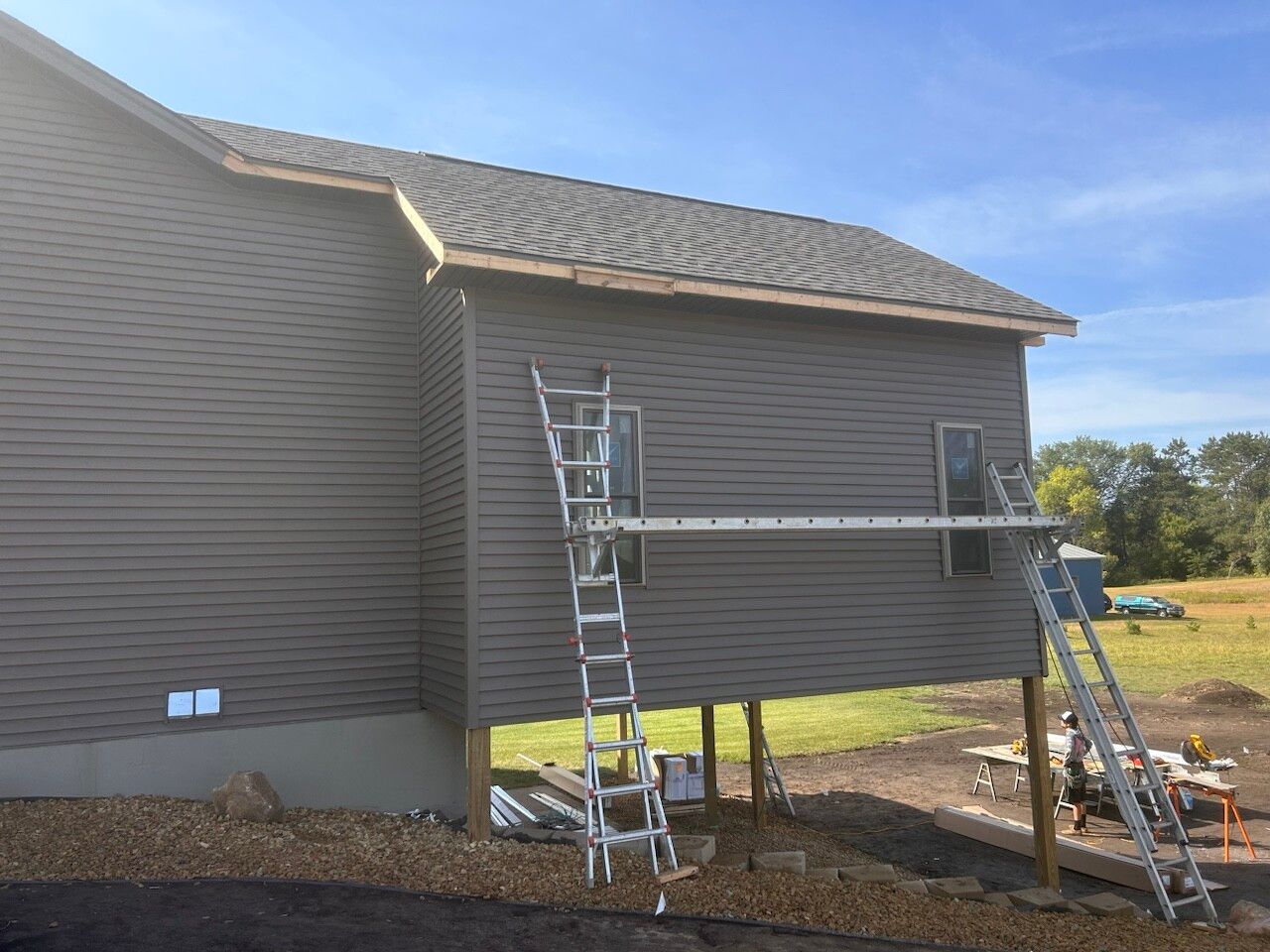 A house is being painted with a ladder on the side of it.