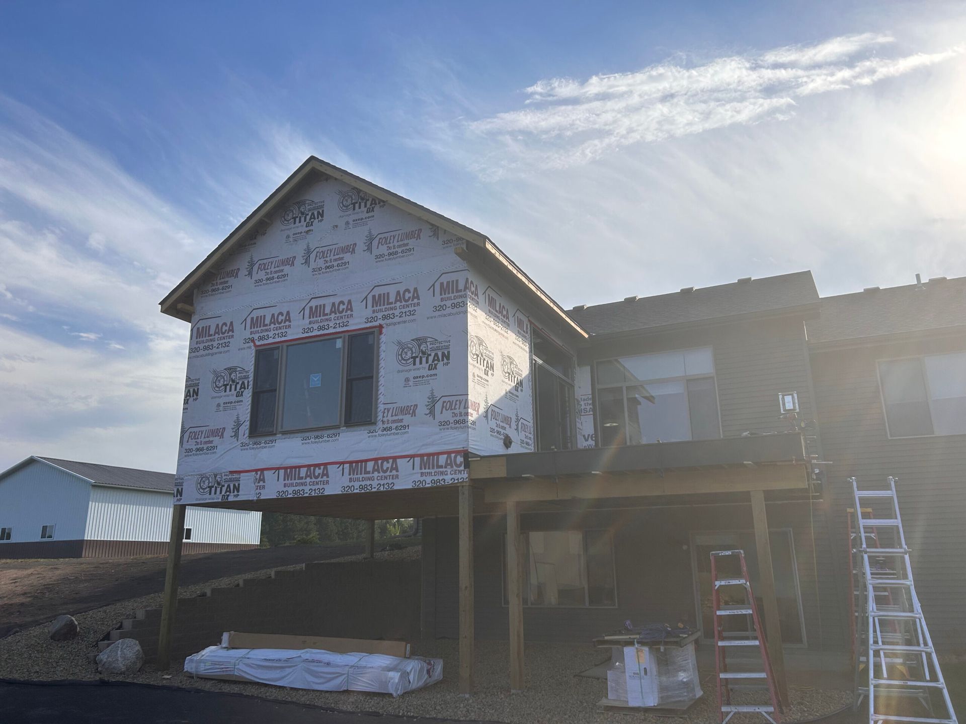 A house is being built on stilts with a ladder in front of it.