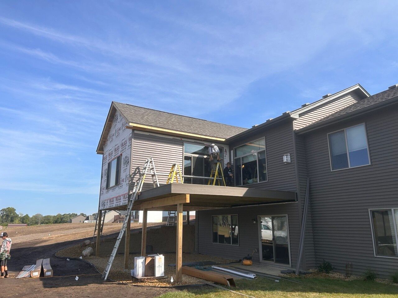 A large house with a large deck under construction.