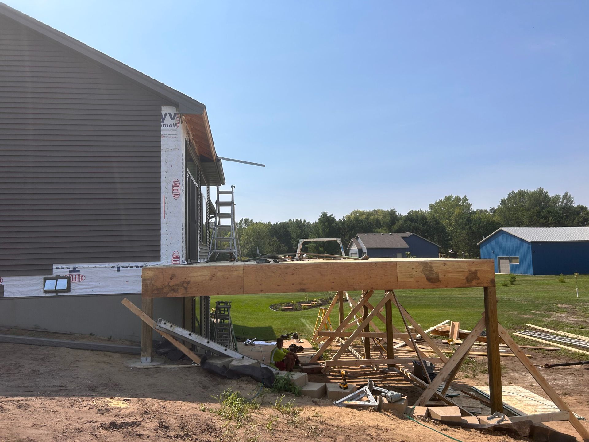 A wooden deck is being built in front of a house.