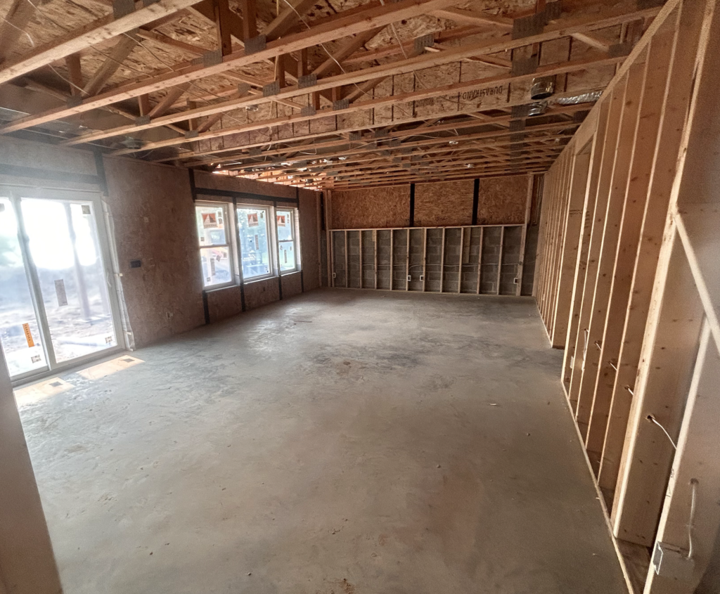 A large empty room with a lot of windows and wooden beams.