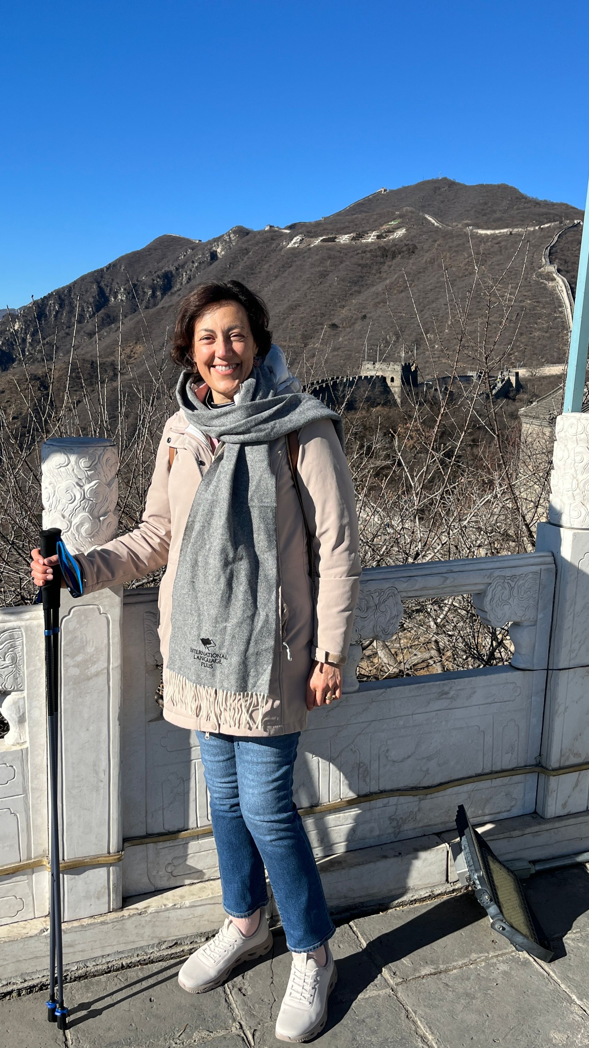 Two men at a table, looking at a book and talking. The man on the right wears a blue 