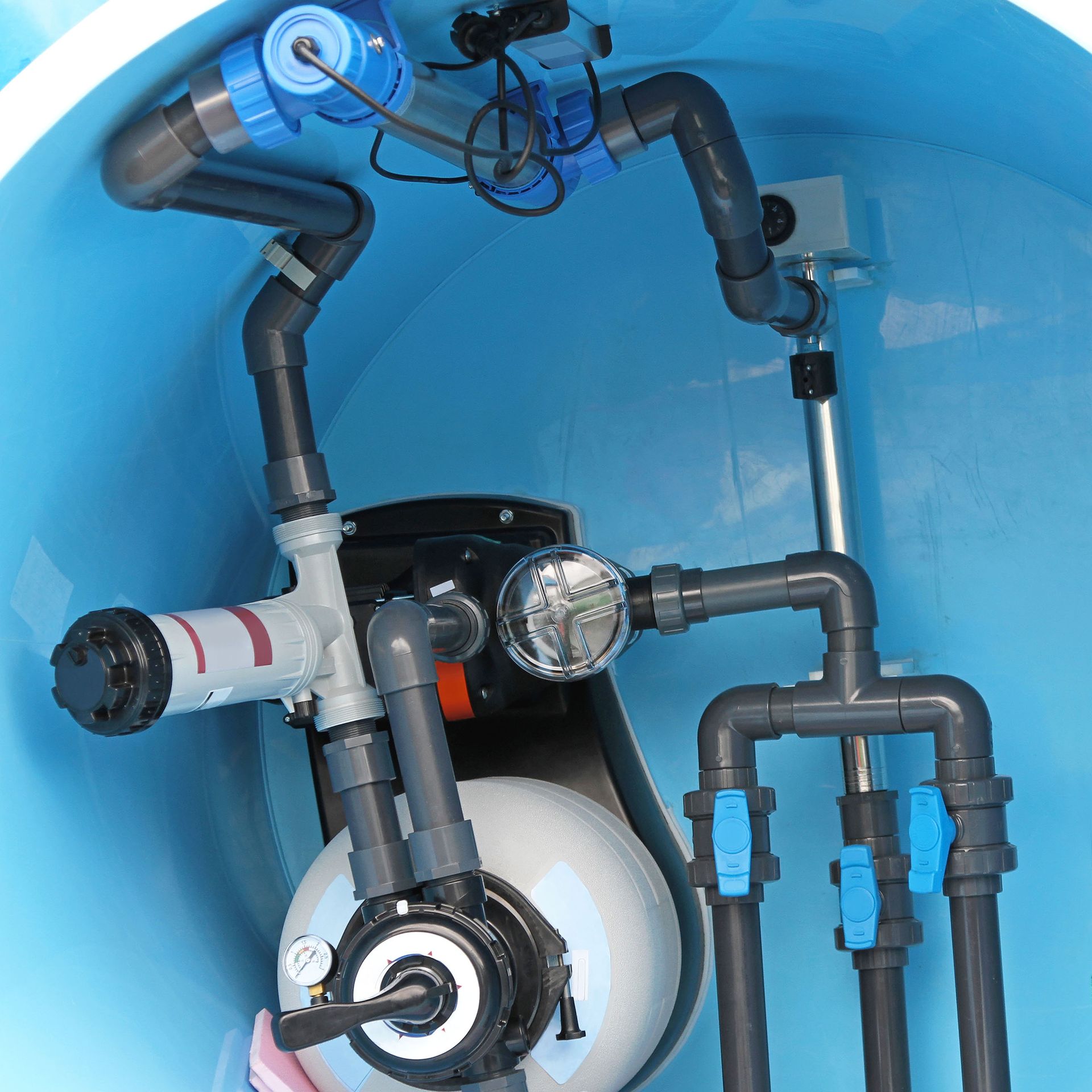 Pool filtration system with blue pipes and valves inside a blue container.
