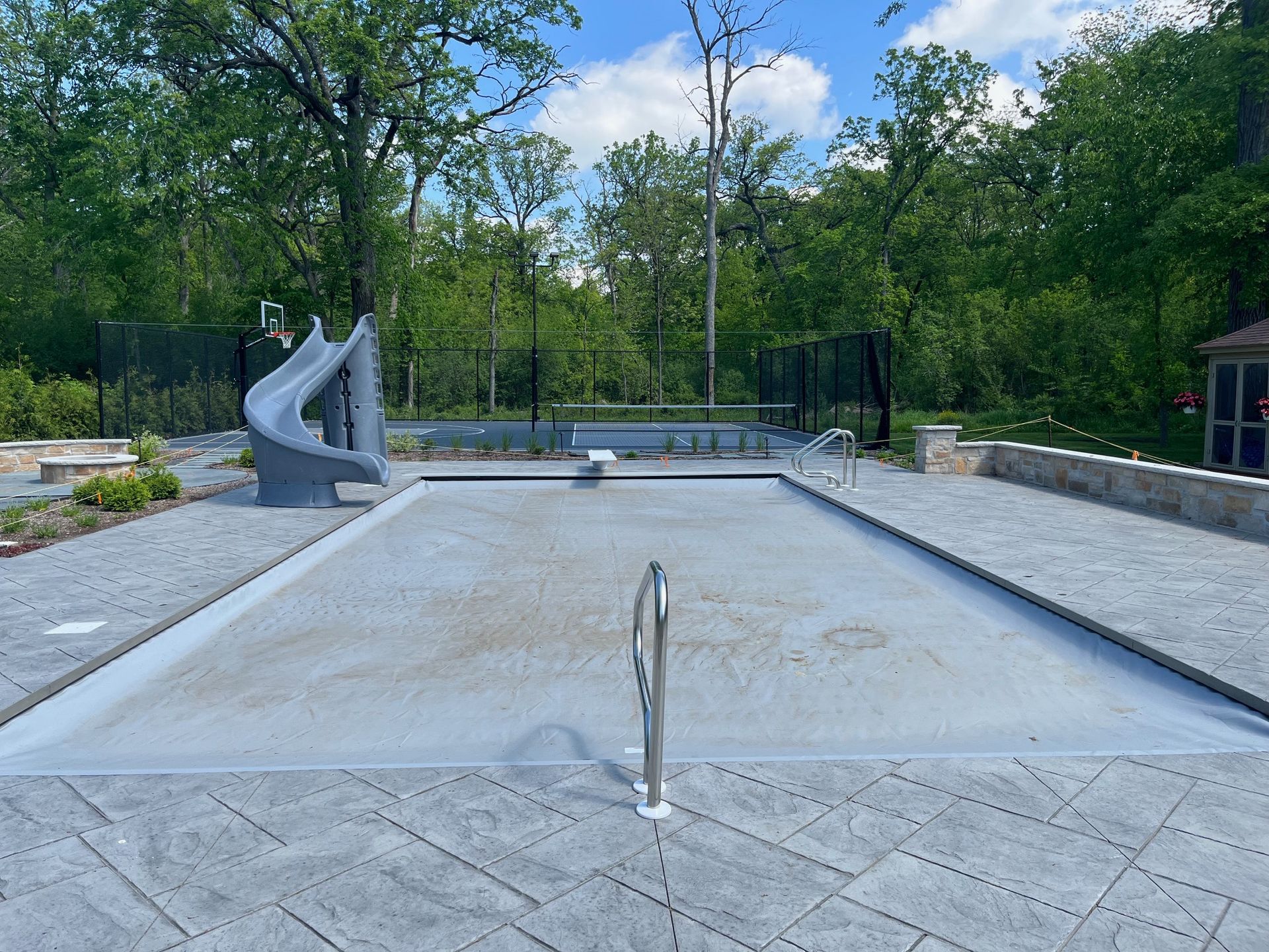 A large swimming pool with a slide in the background