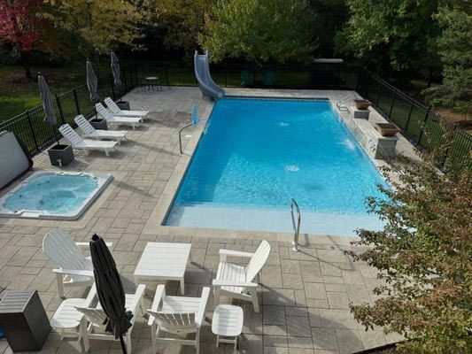 An aerial view of a large swimming pool surrounded by chairs and tables.