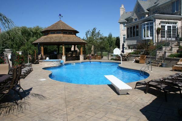 A large swimming pool with a gazebo in the background