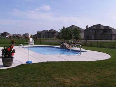 A large swimming pool in a backyard with houses in the background