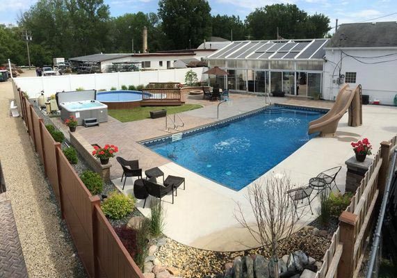 A large swimming pool with a slide and a hot tub